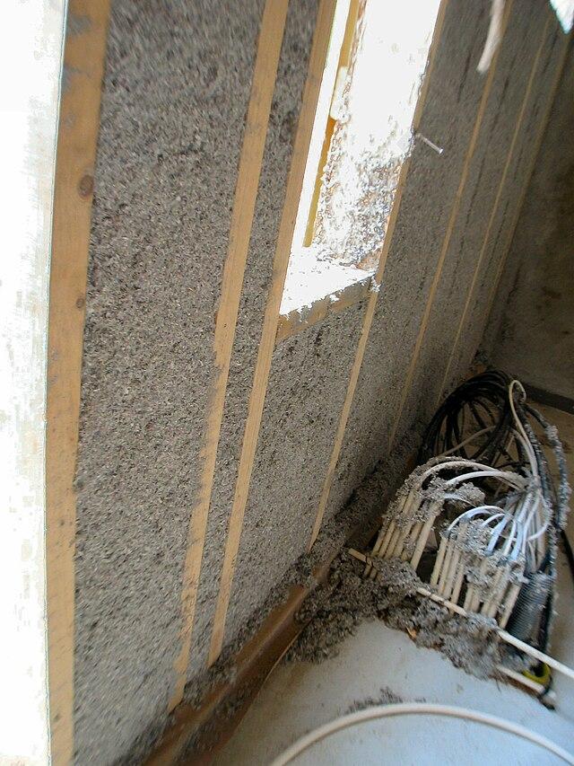 How does insulating buildings affect the amount of fuel needed to keep a building at a stable temperature?
