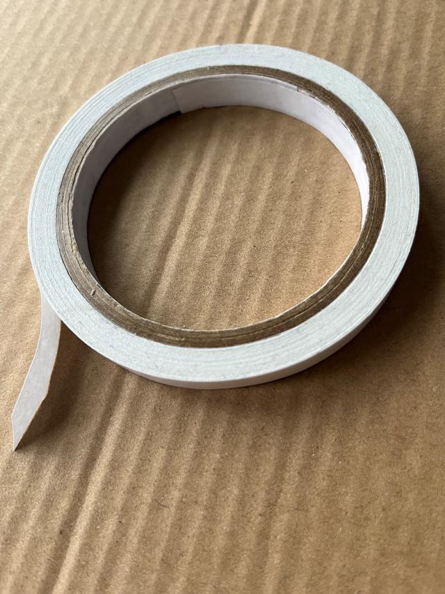 What are the problems of using double-sided tape to hold paper templates to fabric?
